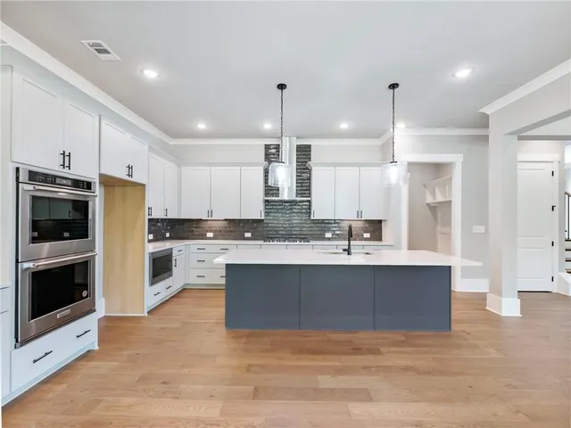 a large kitchen with kitchen island a sink stainless steel appliances and cabinets