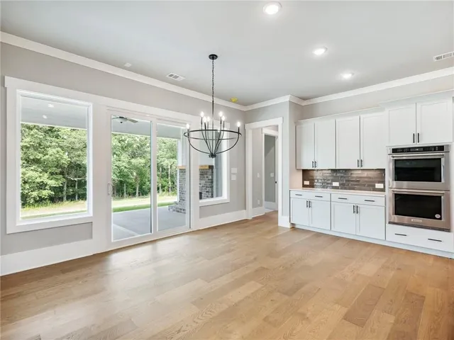 a kitchen with stainless steel appliances granite countertop a stove and a white cabinets