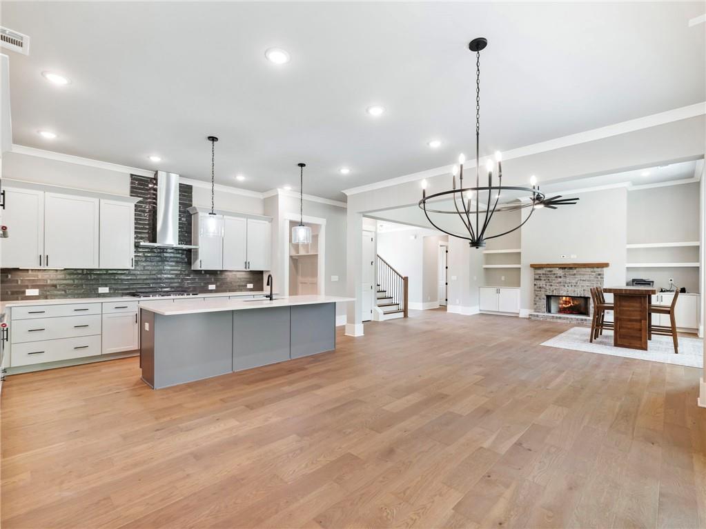 170 Ewing Way Dacula, GA 30019 - Photo 15 of 45 a open kitchen with stainless steel appliances kitchen island granite countertop a stove a sink a chandelier and a living room view