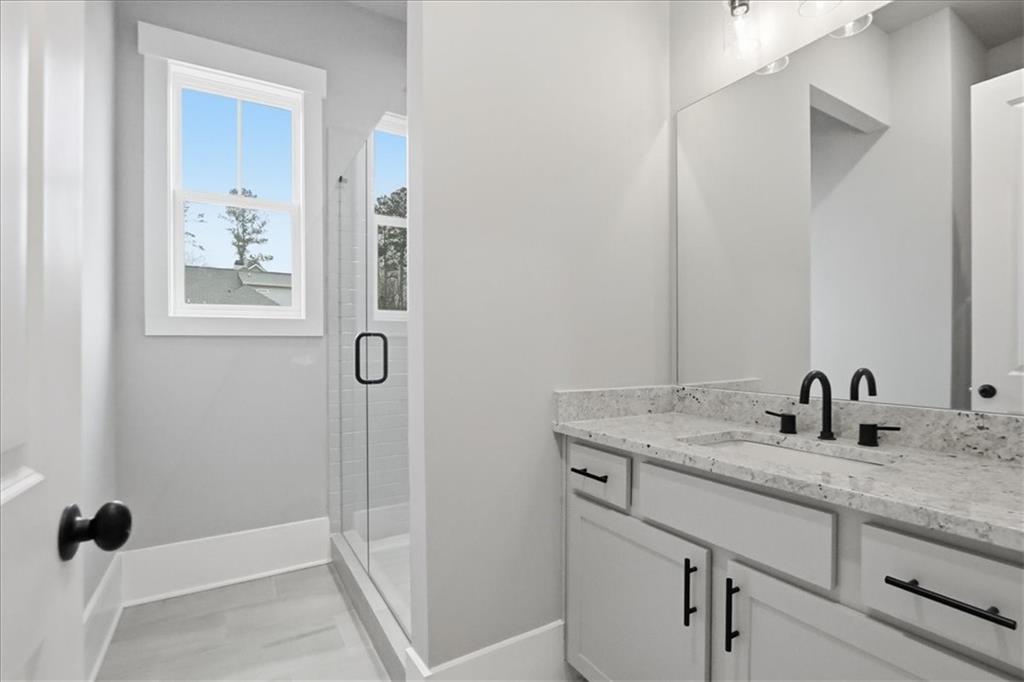 170 Ewing Way Dacula, GA 30019 - Photo 25 of 67 a bathroom with a granite countertop sink a mirror and shower