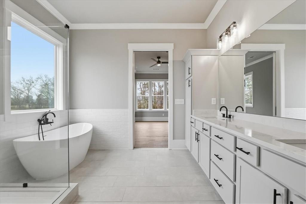 170 Ewing Way Dacula, GA 30019 - Photo 40 of 67 a spacious bathroom with a double vanity sink a mirror a bathtub and window