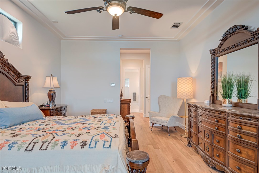 43362 Waterside Trail Punta Gorda, FL 33982 - Photo 17 of 50 a bedroom with a bed and a chandelier