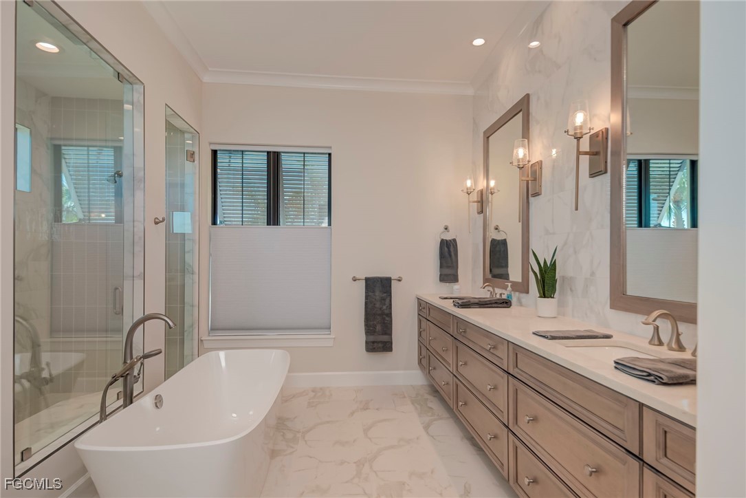 43362 Waterside Trail Punta Gorda, FL 33982 - Photo 18 of 50 a bathroom with a double vanity sink a mirror and a bathtub