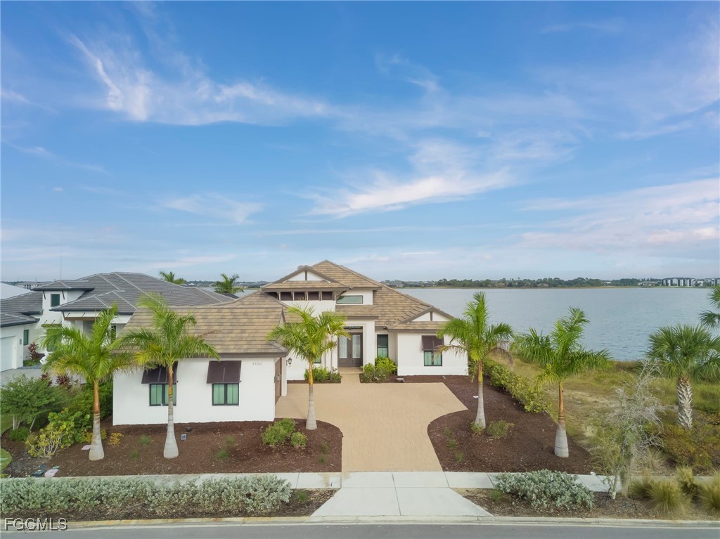 43362 Waterside Trail Punta Gorda, FL 33982 - Photo 2 of 50 a front view of a house with a garden and lake view