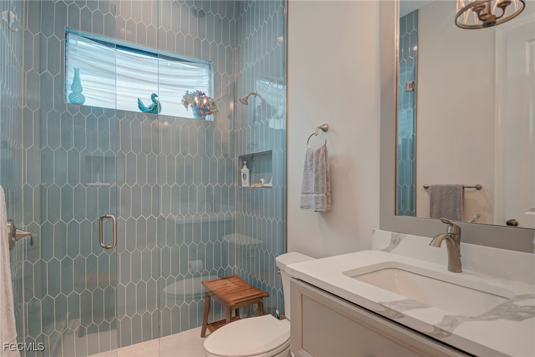 43362 Waterside Trail Punta Gorda, FL 33982 - Photo 24 of 50 a bathroom with a granite countertop sink toilet a mirror and shower