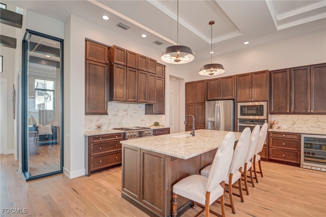 43362 Waterside Trail Punta Gorda, FL 33982 - Photo 9 of 50 a open kitchen with stainless steel appliances granite countertop a stove top oven a refrigerator a sink and dishwasher with wooden floor