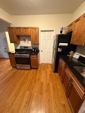 a kitchen with a stove wooden floor and a sink