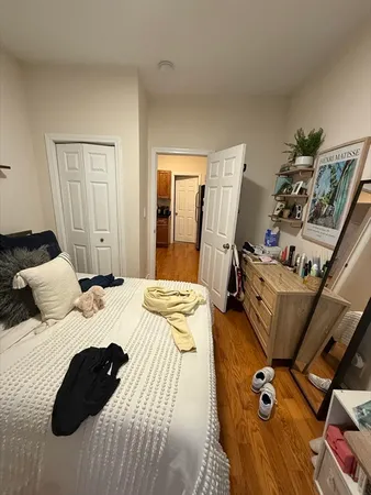 a bedroom with a bed and wooden floor