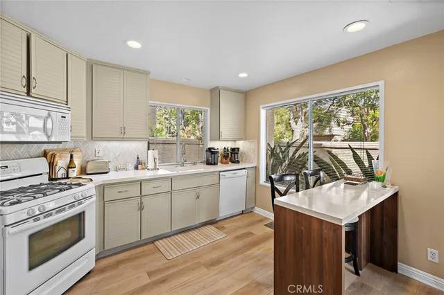 a kitchen with stainless steel appliances a stove a refrigerator a table and chairs