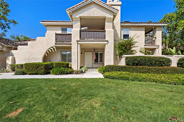 a view of a house with brick walls and a yard with plants