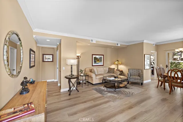 a living room with furniture and a lamp on table with wooden floor