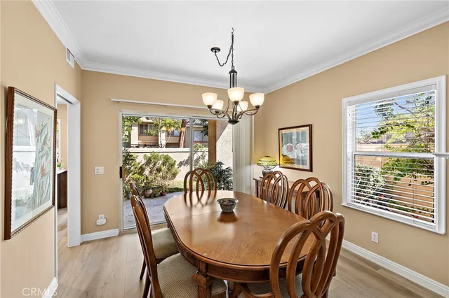 a view of a dining room with furniture a chandelier and wooden floor