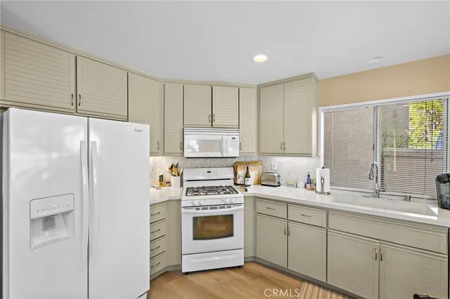a kitchen with stainless steel appliances a stove a refrigerator a table and chairs