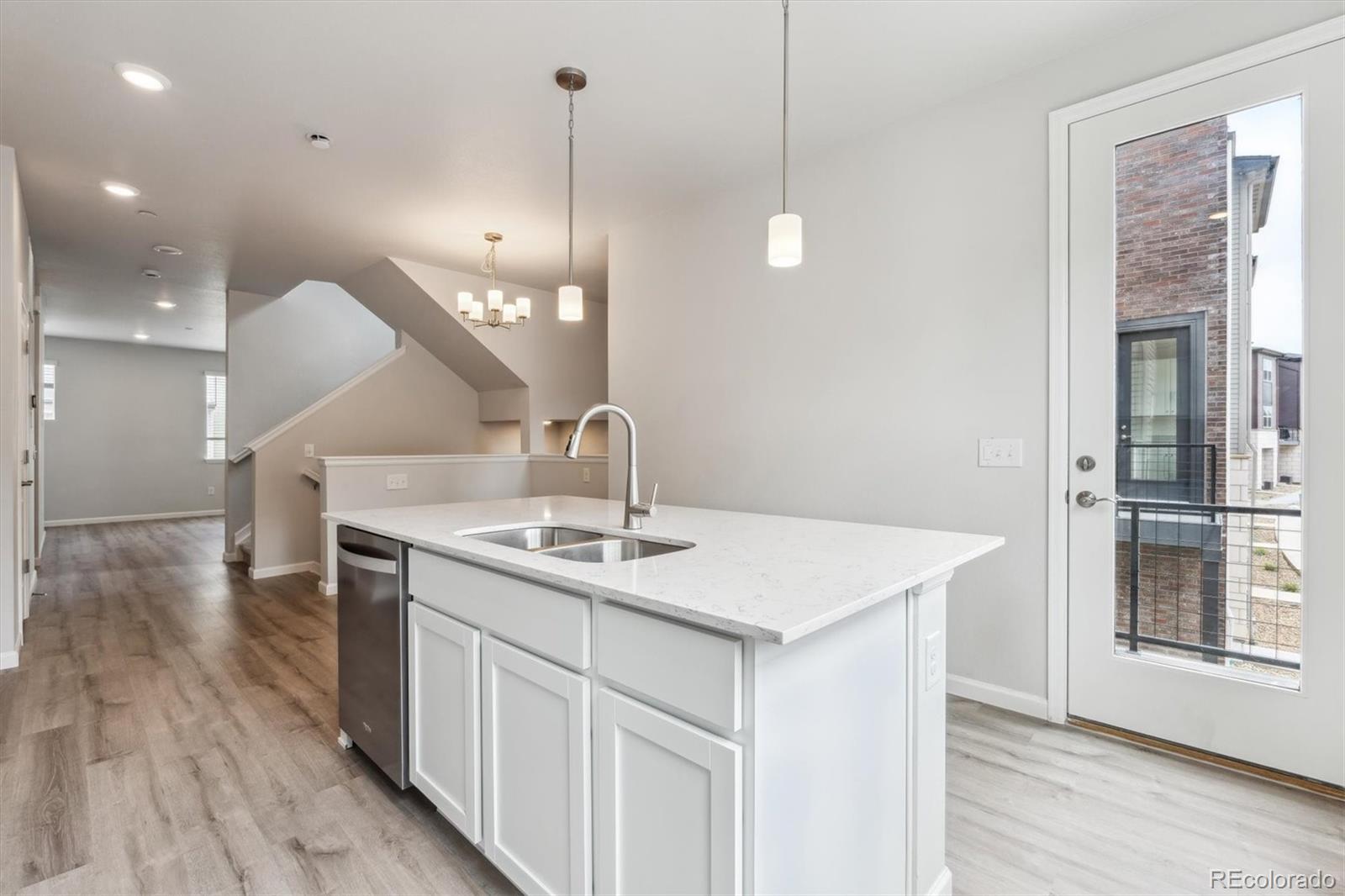 a kitchen with a sink a mirror and wooden floor