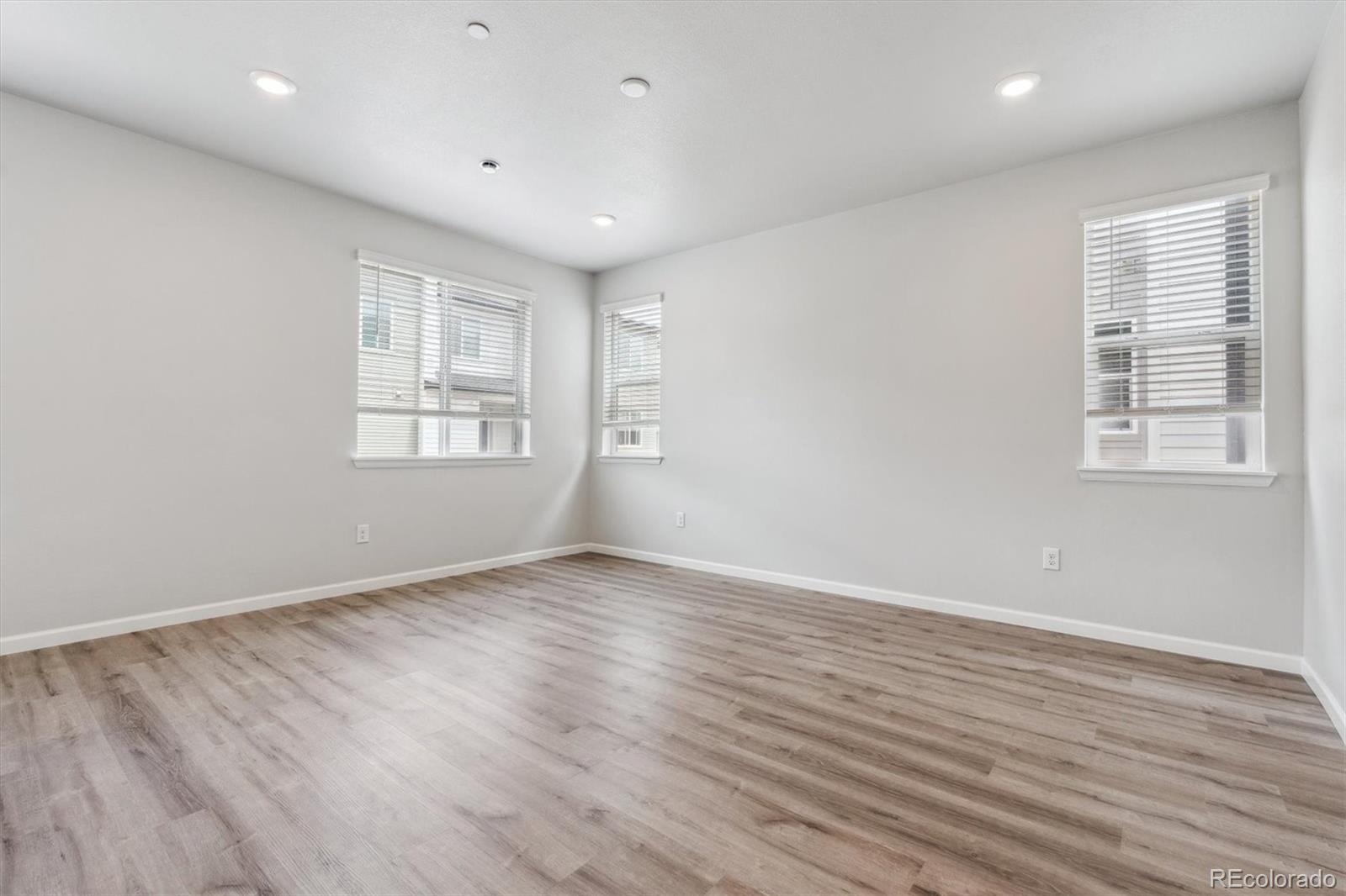 465 Interlocken Boulevard, Unit 101 Broomfield, CO 80021 - Photo 4 of 17 an empty room with wooden floor and windows