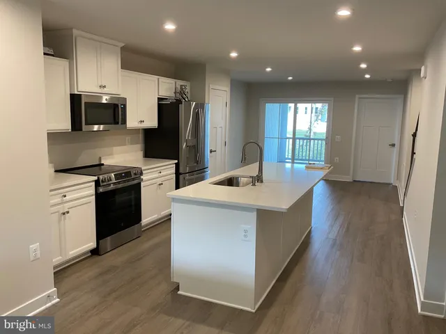 a kitchen with stainless steel appliances a refrigerator and a stove top oven