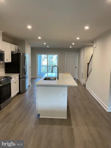 a kitchen with kitchen island a sink and wooden floor