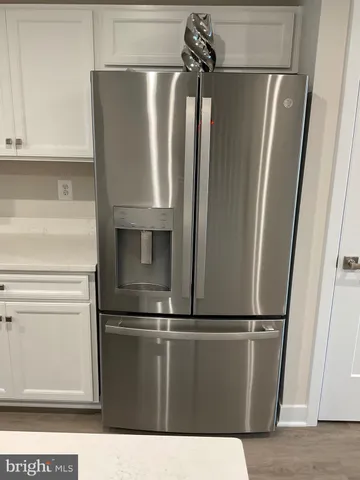 a kitchen with stainless steel appliances a refrigerator a sink dishwasher and a stove with wooden floor