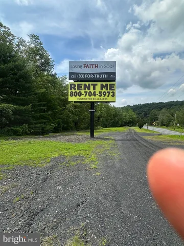 a sign board with a play ground in the back