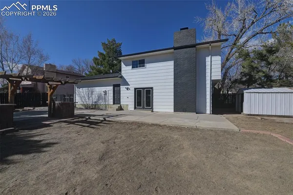a backyard of a house with table and chairs