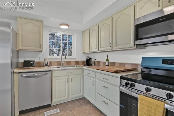 a view of a kitchen with a fridge wooden floor and a window