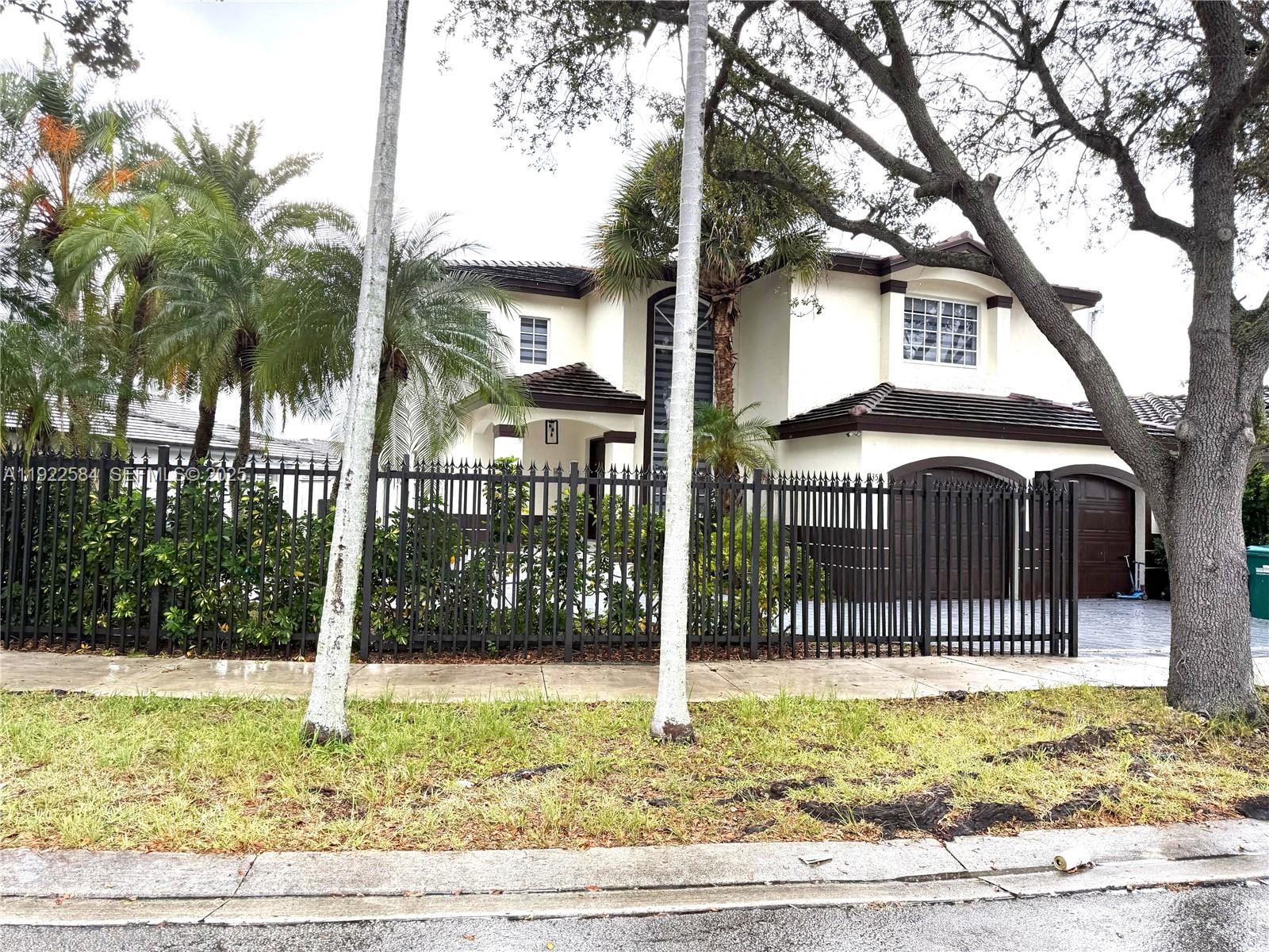 a front view of a house with a garden and tree