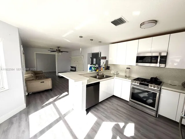 a kitchen with stove a sink and a refrigerator