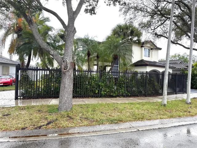a view of a white house with a yard and potted plants