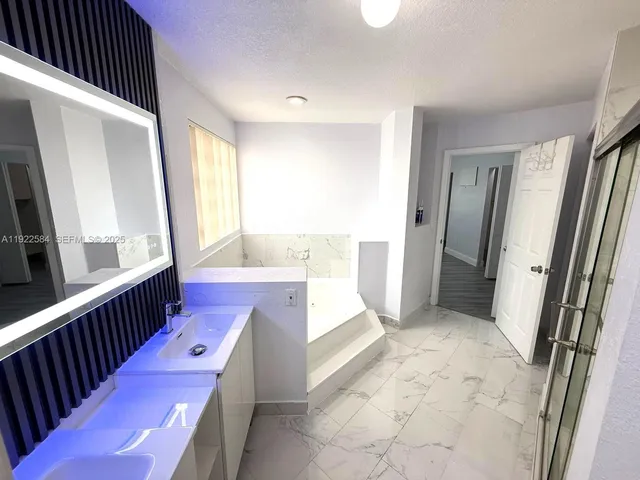 a bathroom with a tub sink and mirror