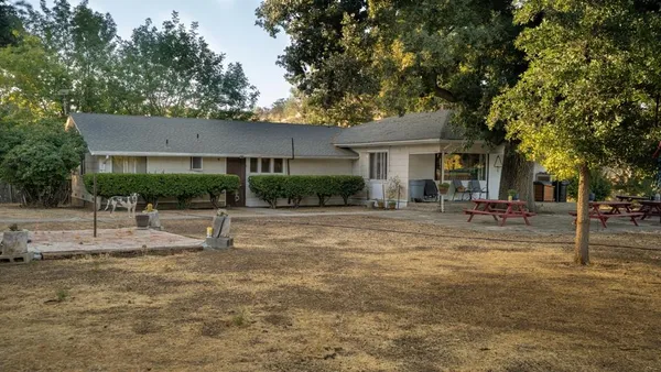 a view of a house with backyard and a tree