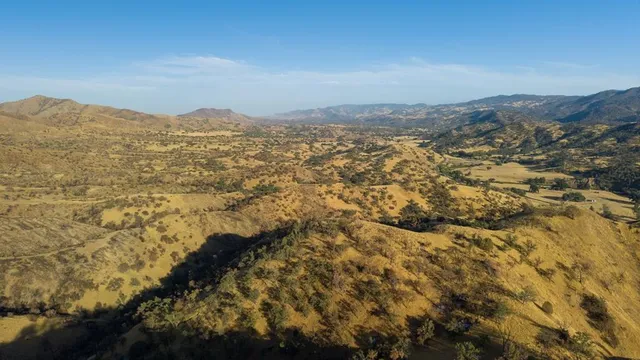 a view of a lake with mountains and valleys in the background