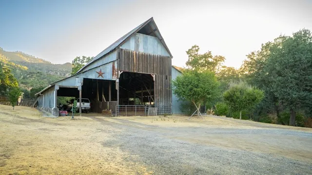 a front view of house with yard and trees in the background