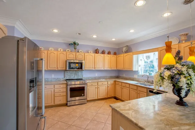 a kitchen with stainless steel appliances granite countertop a sink and a refrigerator