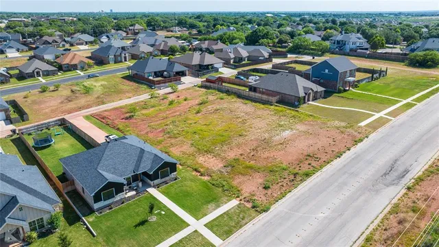 an aerial view of a house with a garden and lake view