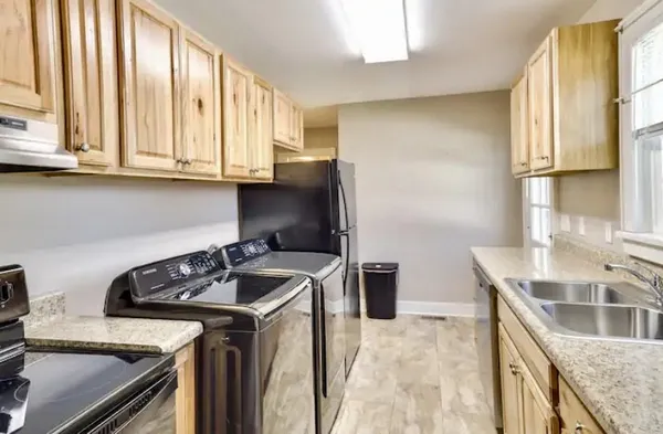 a kitchen with granite countertop a stove sink and cabinets