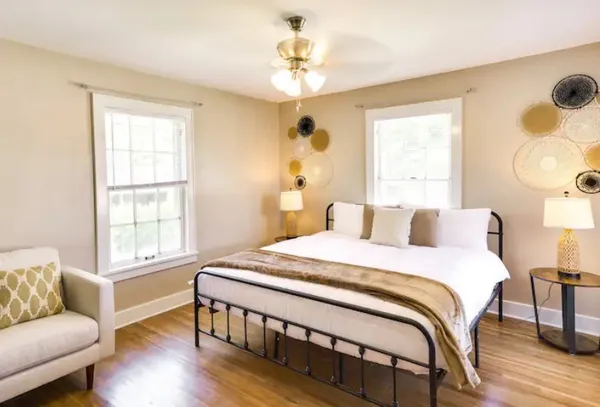 a bedroom with a bed and a window with wooden floor