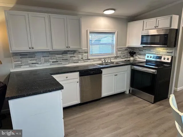 a kitchen with stainless steel appliances a sink stove and microwave