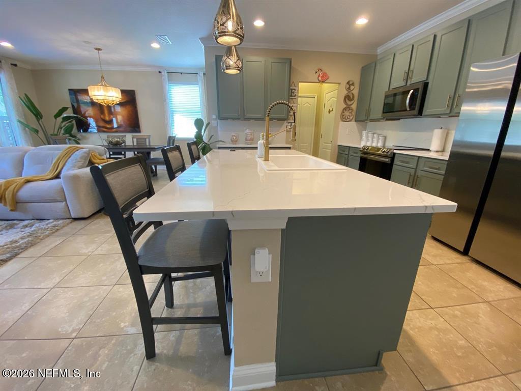 115 Sierras Loop St. Augustine, FL 32086 - Photo 16 of 65 a large kitchen with a table chairs and a refrigerator