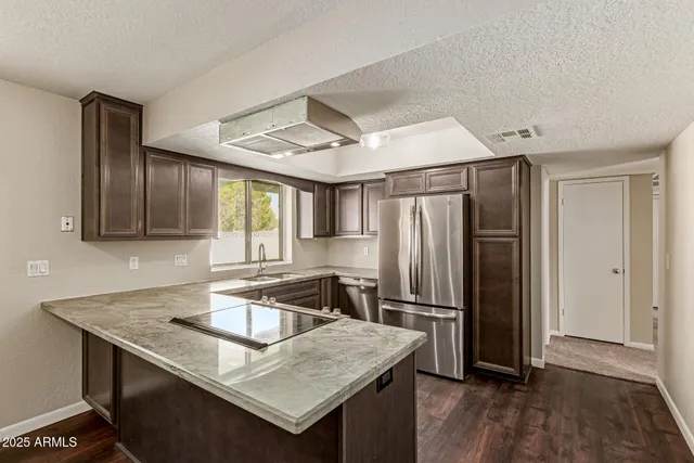 a kitchen with stainless steel appliances granite countertop a sink refrigerator and microwave