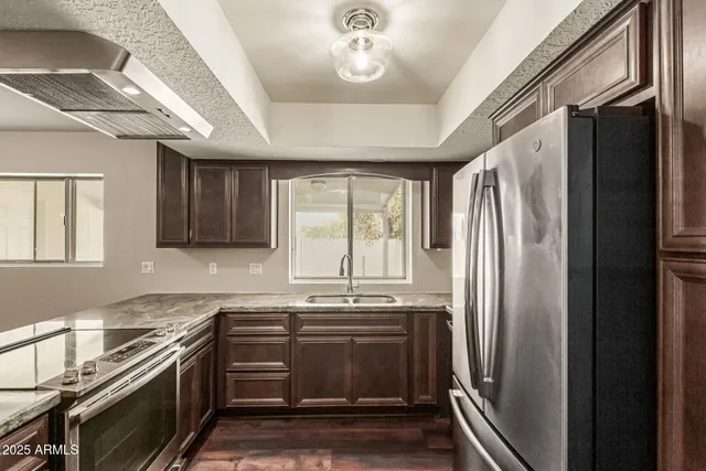a kitchen with stainless steel appliances a stove a refrigerator and a sink