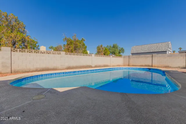 a view of swimming pool with outdoor seating and yard in back