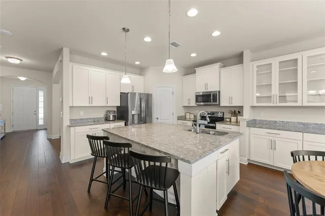 a kitchen with stainless steel appliances granite countertop a sink a stove and a refrigerator
