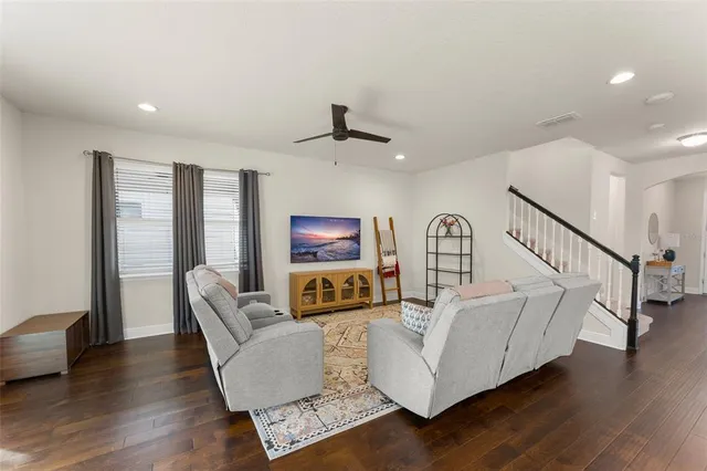 a living room with furniture and a view of kitchen