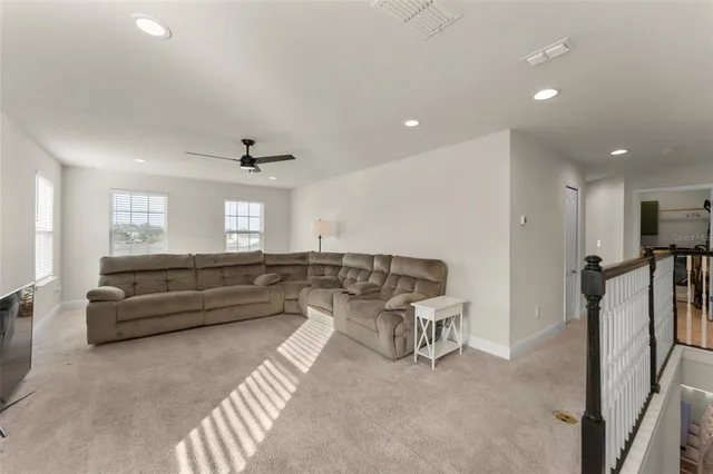 a living room with furniture and a ceiling fan