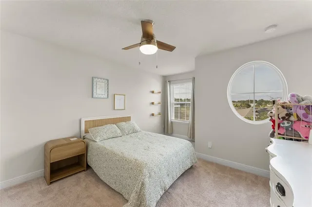 a view of a bedroom with bed and ceiling fan