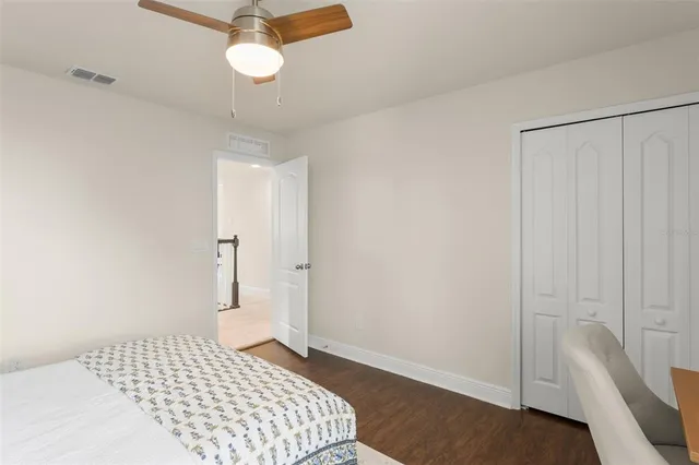 a spacious bedroom with a large bed and a chandelier