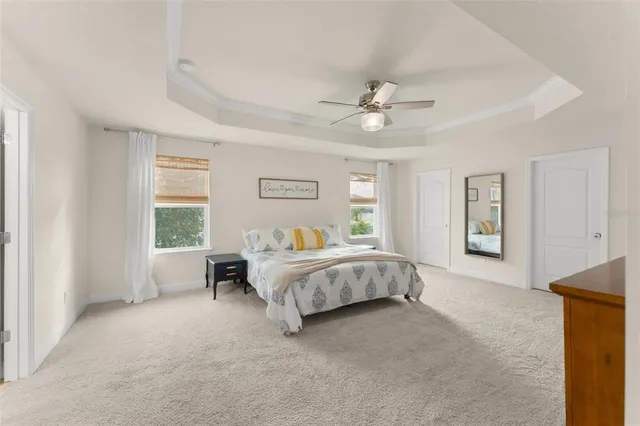 a spacious bedroom with a bed and a ceiling fan