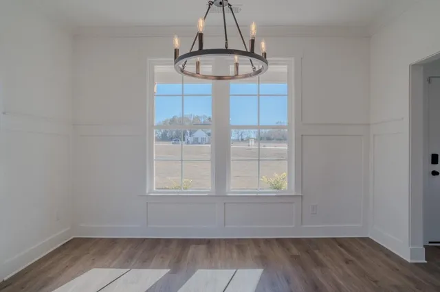 a view of a hallway with wooden floor and closet
