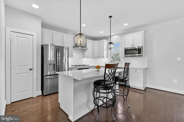 a very nice looking kitchen with granite countertop a stove a sink a dining table and chairs