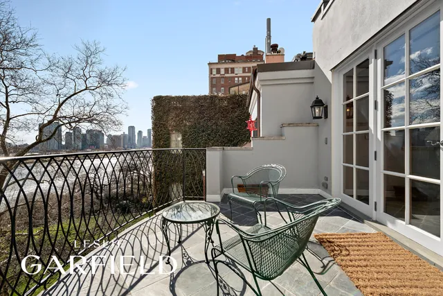 a front view of a house with large trees